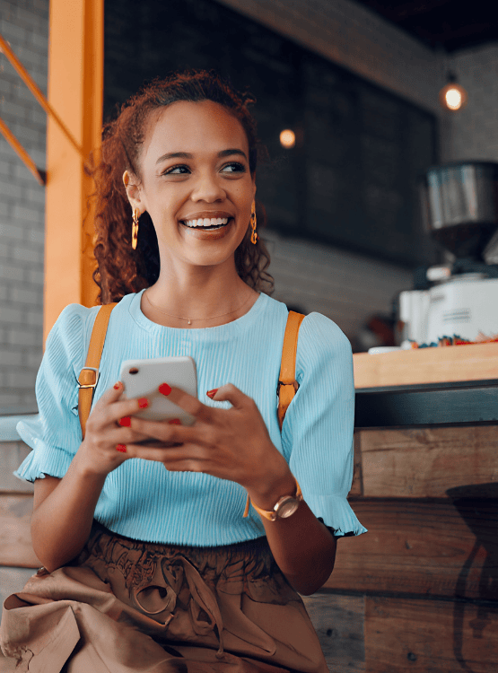 Young adult using her phone at outdoor drink stand. 
