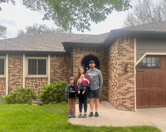 Young family in front of their new home purchase. 