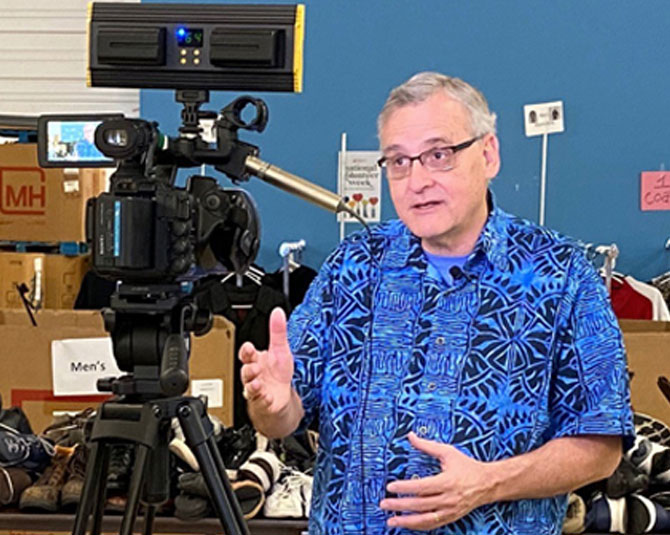 Pastor Tom of Lincoln City Mission speaking in front of camera. 