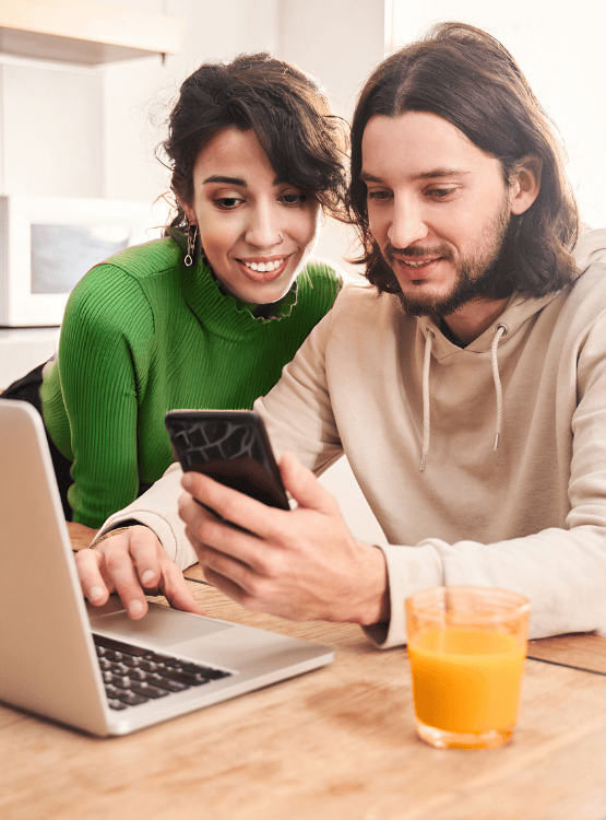 Couple working on computer and phone.