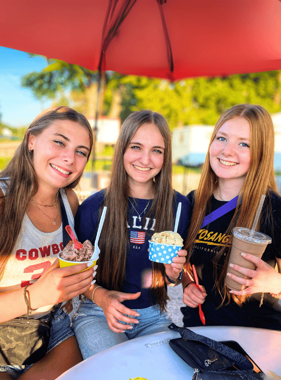Teenagers eating ice cream on sunny day. 