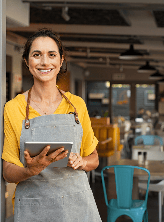 Woman smiling and greeting customers at restaurant.