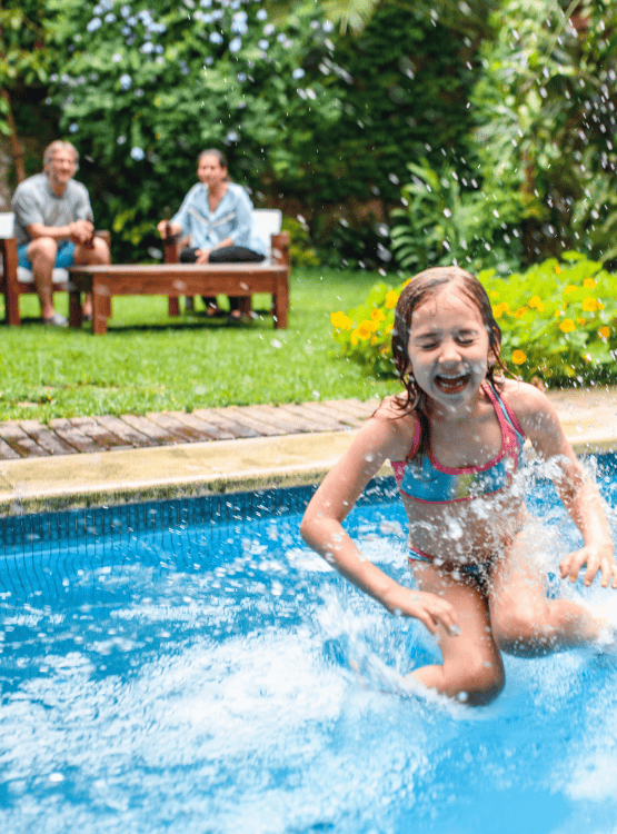 Parents watching child splash in pool.  