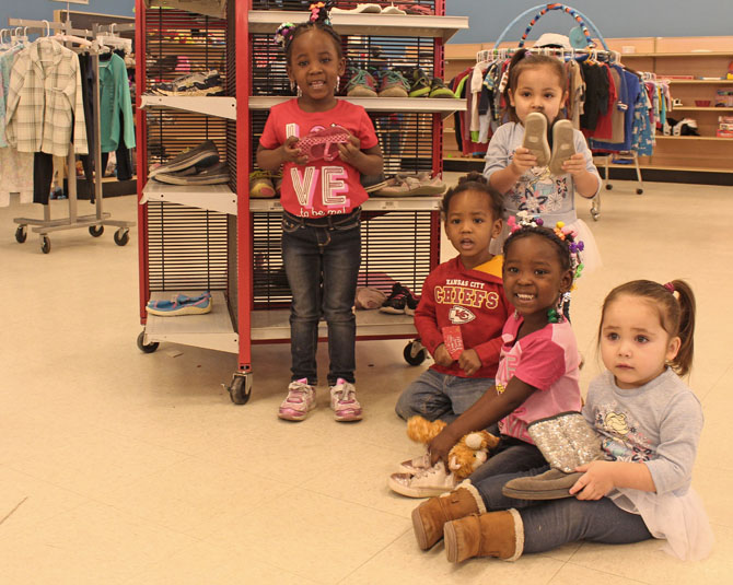 Group of young girls smiling holding their new shoes
