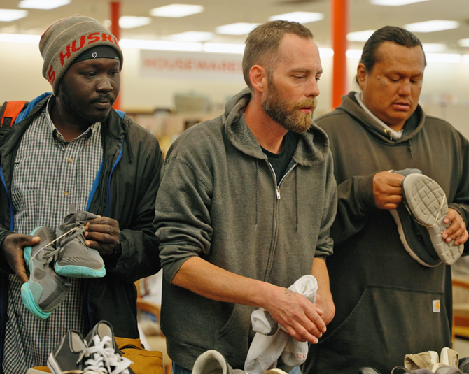 Men looking through a table to find new shoes