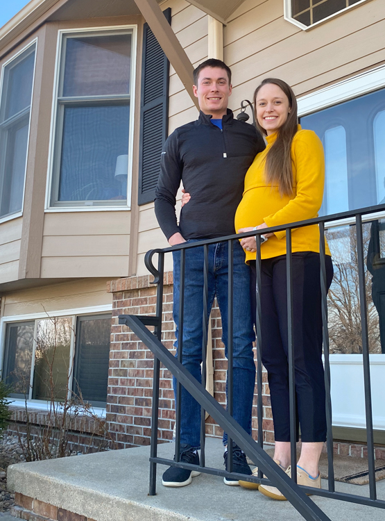Couple posing on their porch of their new home thanks to Cornhusker Bank