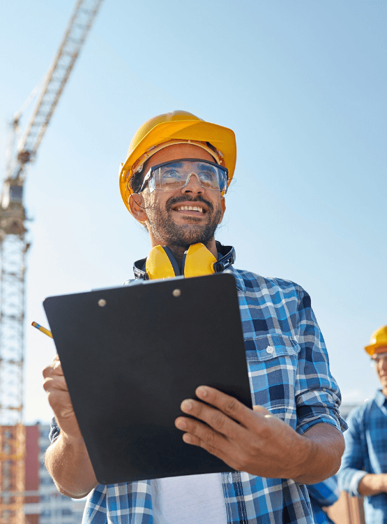 Male construction worker with clipboard on jobsite. 